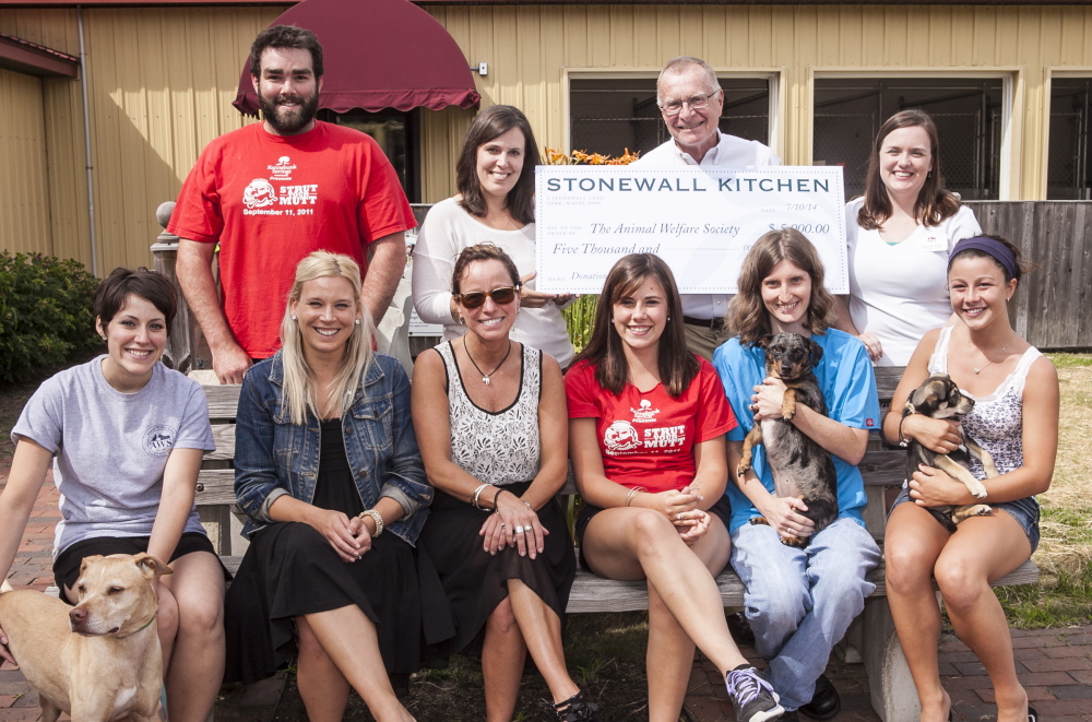 Local specialty food manufacturer and retailer Stonewall Kitchen, headquartered in York, recently donated $5,000 to the Animal Welfare Society (AWS) of West Kennebunk. Pictured are Stonewall staffers with AWS volunteers and some of the animals who will directly benefit from the donation.