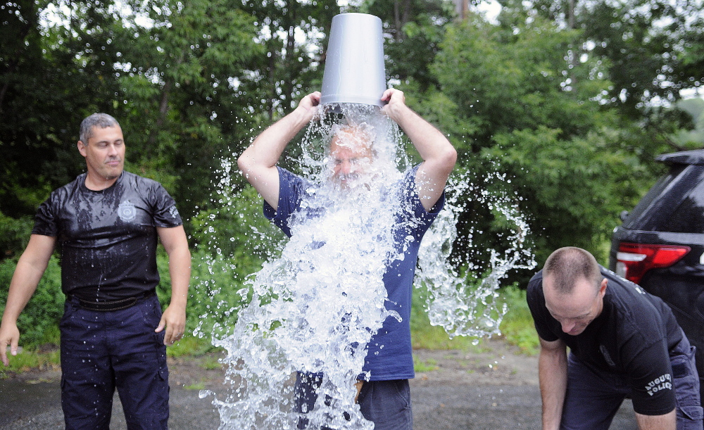 Augusta police dispatcher Mike Rankins dumps a bucket of ice over his head Aug. 13 to raise money to fight ALS. Federal government funding for research into ALS and other diseases has been slashed in the past few years.