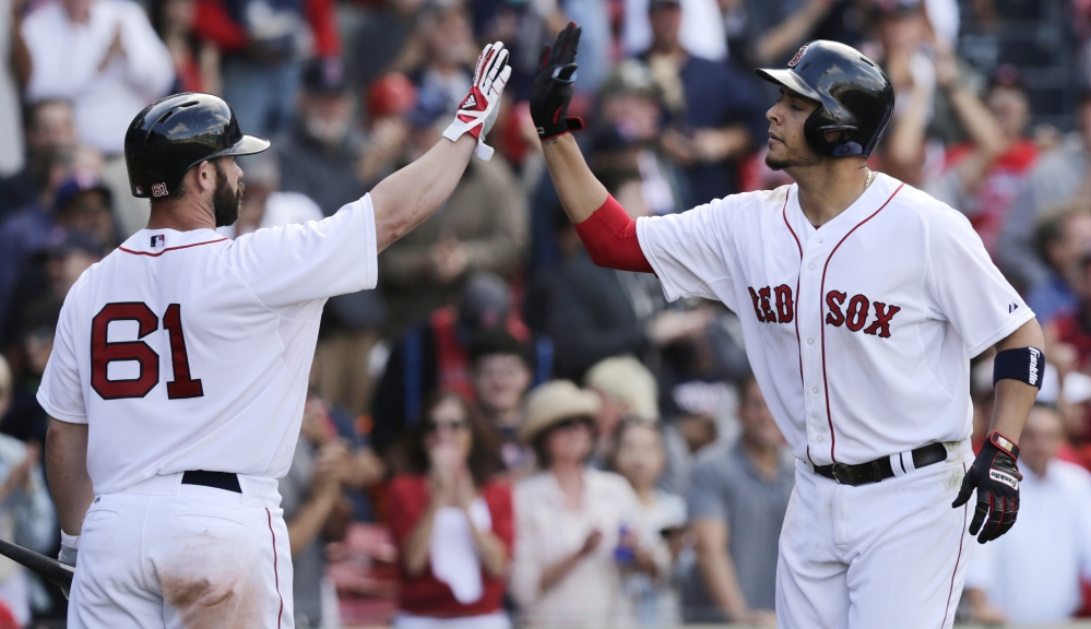Red Sox third baseman Carlos Rivero, right, is congratulated by teammate Dan Butler after his three-run home run off Baltimore Orioles pitcher Joe Saunders in the ninth inning  at Fenway Park in Boston on Wednesday.