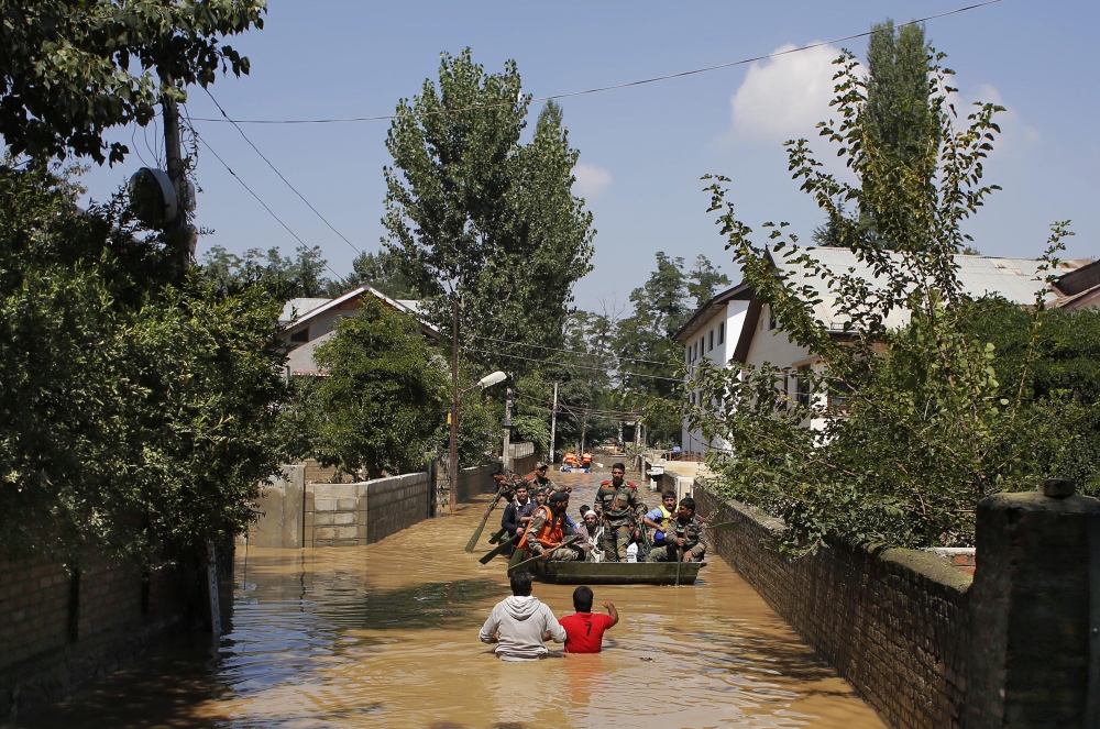 Kashmiri volunteers, back toward camera, give directions to Indian army soldiers trying to rescue flood-affected people in Srinagar, Indian-controlled Kashmir, on Wednesday. 