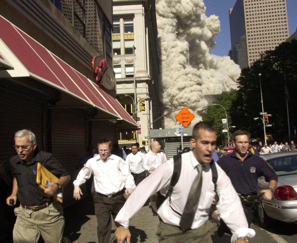 People run as the World Trade Center collapses in New York on Sept. 11, 2001. More than a decade later, America and its allies prepare for conflict with Islamic militants.