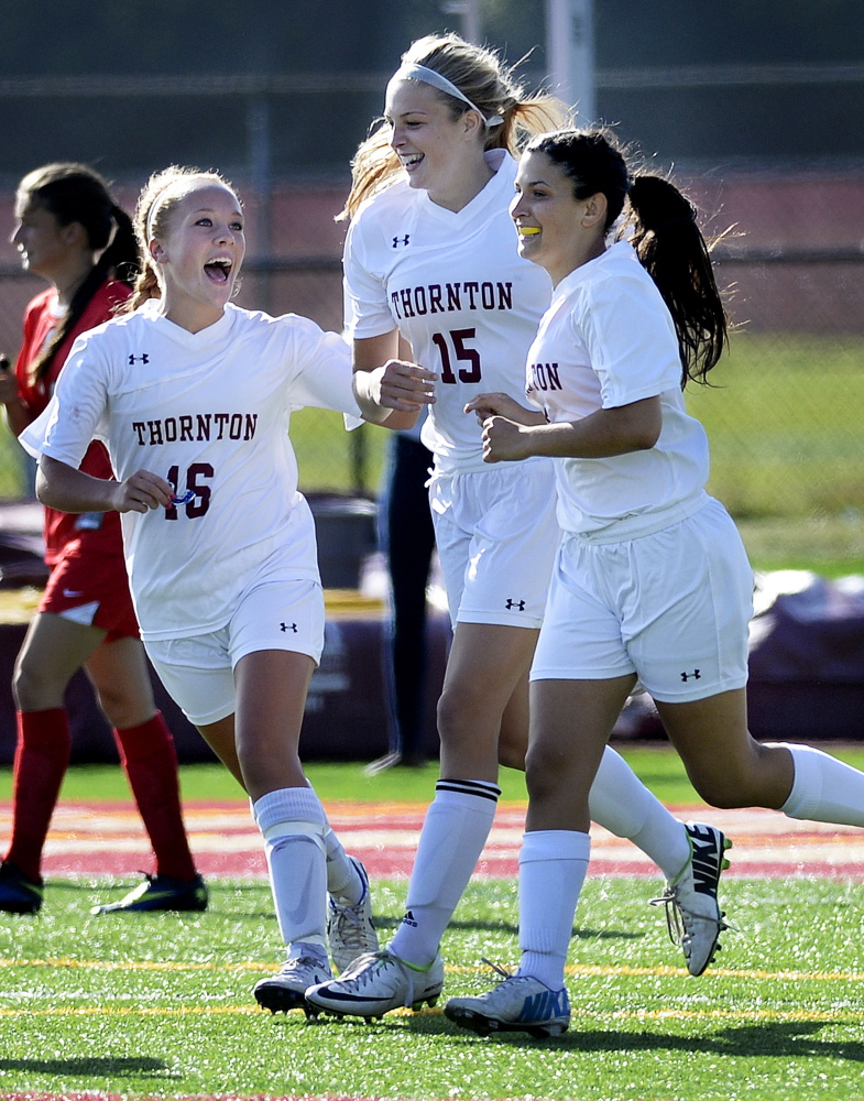 Katherine Gillespie, left, Cassidy Cochrane and Haley DaGraca celebrate an early goal for Thornton Academy in Wednesday’s 6-1 over South Portland. The Trojans had five goals in the first 10 minutes.