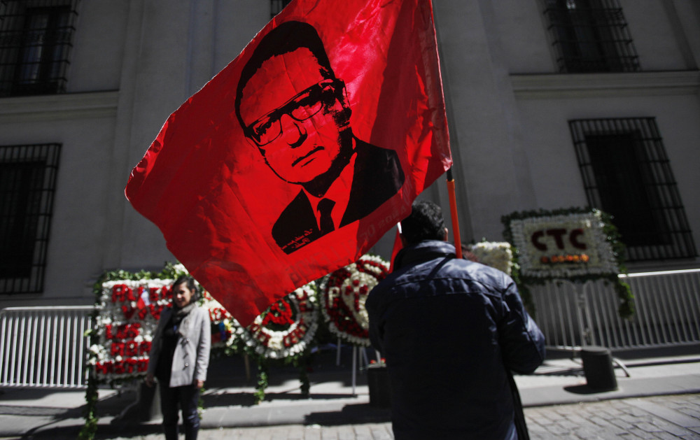 A man holds a flag bearing a portrait of Salvador Allende in Santiago, Chile, on Thursday as Chile’s president marked the anniversary of the 1973 coup that toppled Allende.