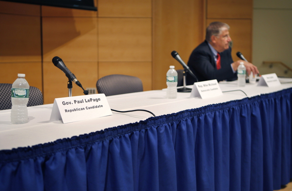 A seat at a table reserved for Gov. Paul LePage remains vacant after the governor decided to pull out of an energy forum at the University of Southern Maine in Portland on Friday. The Republican governor objected to the format for the event when he learned he would have to share the stage with the other gubernatorial candidates including independent Eliot Cutler, right.
