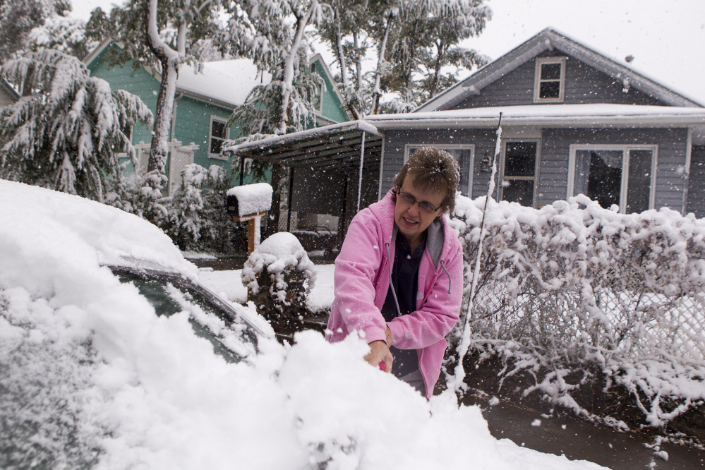 Terry Chandler clears snow off her car before heading to work Thursday in Gillette, Wyo. A snowstorm Wednesday and Thursday dumped up to 20 inches in some parts of Wyoming and sent overnight temperatures plummeting into the 20s in some areas.