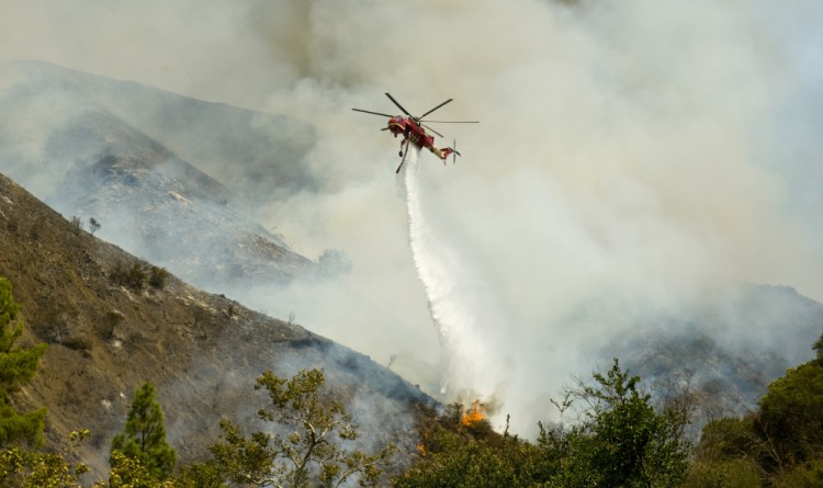An Orange County Fire Authority helicopter drops a load of water on a brush fire in Silverado Canyon in Orange County, Calif. on Friday.