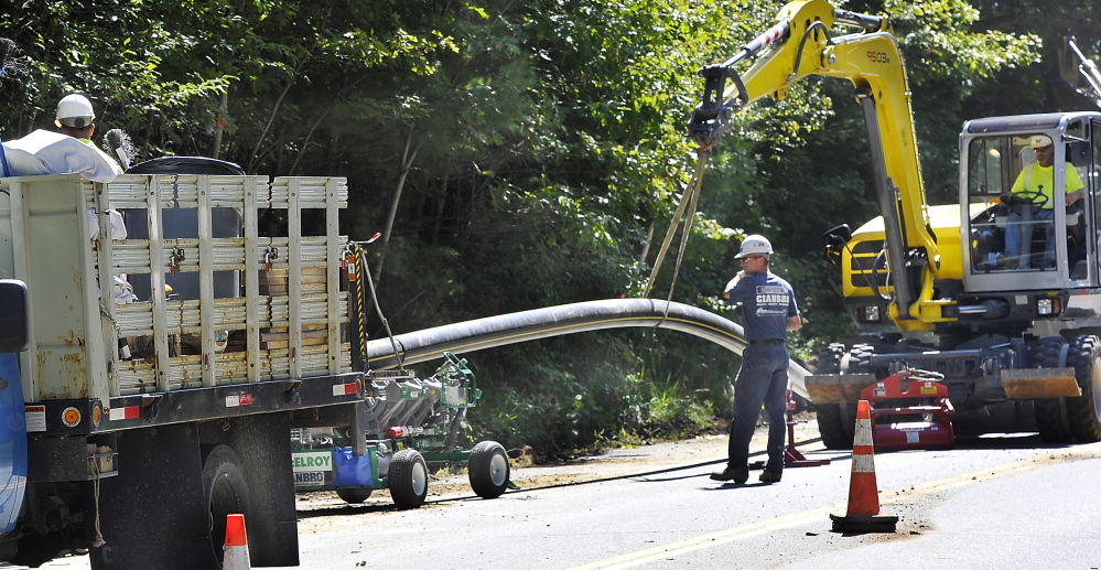 CUMBERLAND, ME - SEPTEMBER 10: A Cianbro crew removes the 8' pipe from the fusing machine after it cured as they prepare the pipe for burial along Route 88 in Cumberland Foreside.