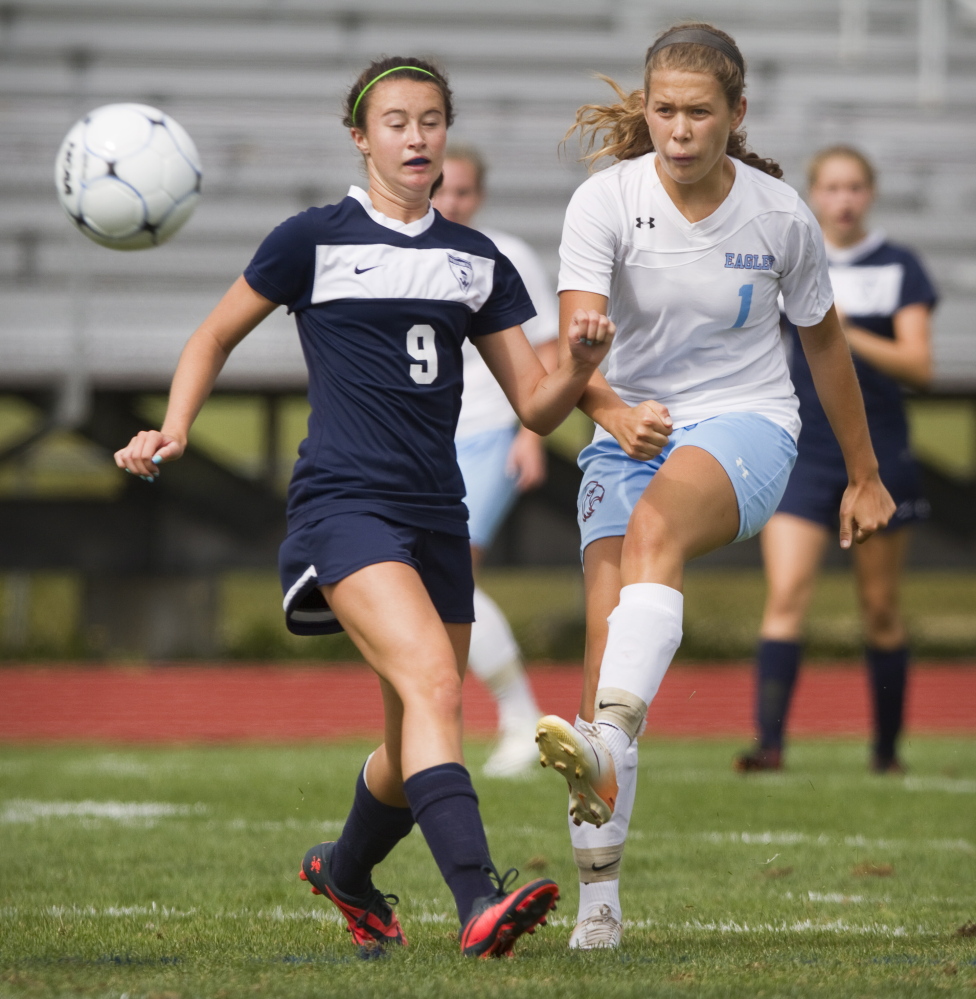 Windham’s Shannon Valente passes the ball under pressure from Janessa Corbett of Westbrook. Windham help Westbrook without a shot and improved its record to 3-0.