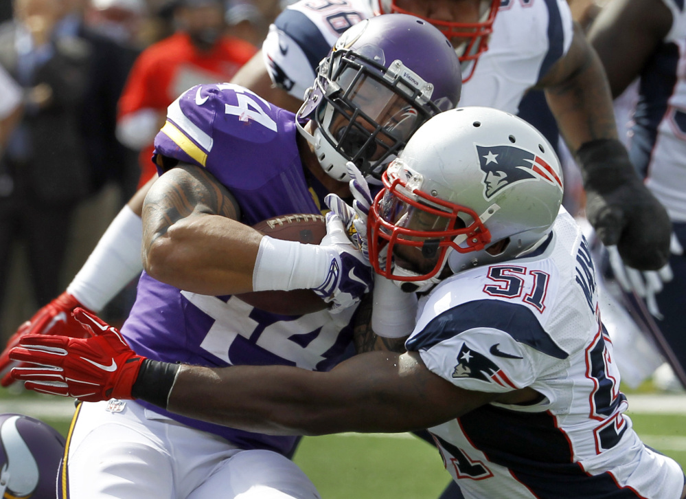 Minnesota Vikings running back Matt Asiata, left, is stopped for a 2-yard loss by New England Patriots linebacker Jerod Mayo in the first quarter of Sunday’s game at Minneapolis.