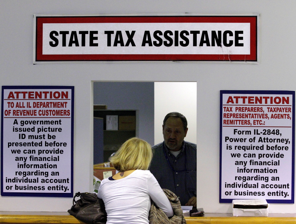 In this April 16, 2012 file photo, an Illinois Department of Revenue employee offers assistance to income tax payers at the Illinois Department of Revenue in Springfield, Ill. The widening gap between the wealthiest Americans and everyone else has been matched by a slowdown in state tax revenue, according to a report being released Monday by Standard & Poor’s.