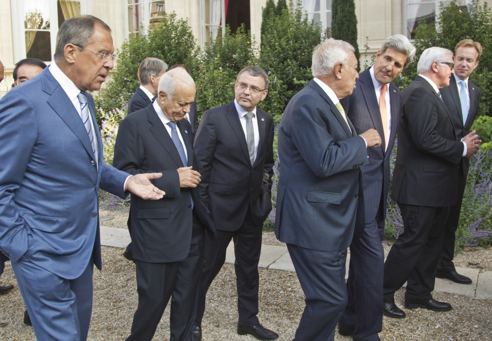 From left, Russian Foreign Minister Sergei Lavrov, Secretary General of the Arab League Nabil al Arabi, Czech Republic Foreign Minister Lubomir Zaoralek, Spanish Foreign Minister Jose Manuel Garcia-Margallo, U.S. Secretary of State John Kerry, German Foreign Minister Frank-Walter Steinmeier, Norwegian Foreign Minister Borge Brendem, walk back to the conference room after a group photo at the French Foreign ministry in Paris.
