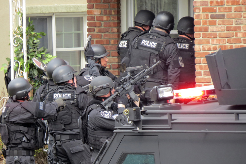 Nassau County police officers enter a home in Long Beach, N.Y., in April in search of an armed killer, based on a phone call that turned out to be a hoax that cost the department $100,000.