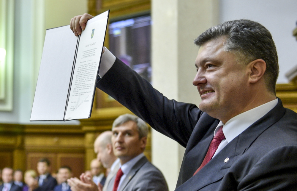 Ukrainian President Petro Poroshenko shows the agreement with the European Union to lawmakers after its signing in parliament in Kiev on Tuesday.