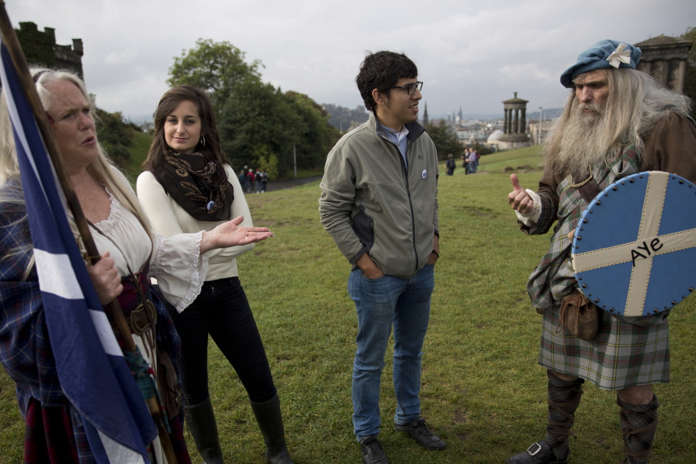 Supporters of Scottish independence chat with members of a historical re-enactment group in Edinburgh on Tuesday. The Yes side says independence will give Scots political control and economic prosperity.