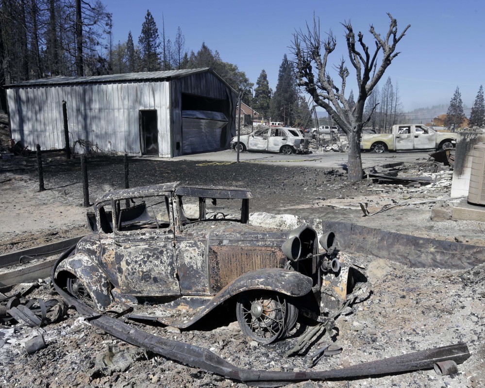 An antique car occupies a garage that was destroyed by a fire Tuesday in Weed, Calif. In just a few hours Monday, wind-driven flames destroyed or damaged 100 homes in the community of 3,000 people, all of whom were evacuated.