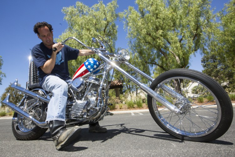 Michael Eisenberg, sits on the customized Captain America chopper Peter Fonda rode in “Easy Rider” at the Profiles in History auction house in Calabasas, Calif.  Eisenberg, a California businessman who once co-owned a Los Angeles motorcycle-themed restaurant with Fonda and “Easy Rider” co-star Dennis Hopper, owns the motorcycle that has come to symbolize the counterculture of the 1960s.