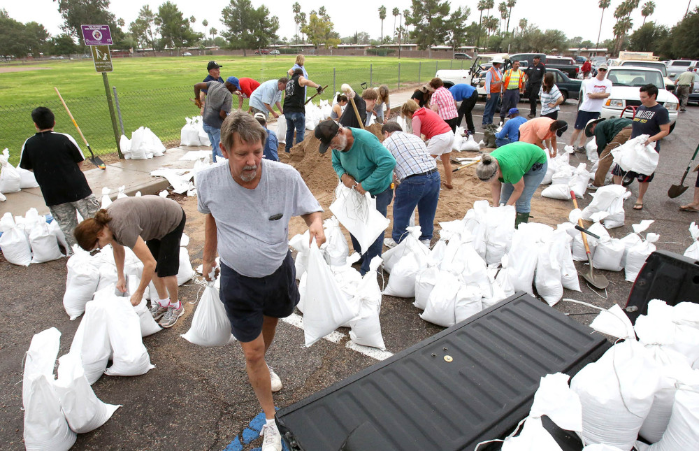 A man carries sand bags from Fort Lowell Park for delivery to friends preparing to deal with rains from Tropical Storm Odile, which arrived in Tucson, Ariz., on Wednesday.