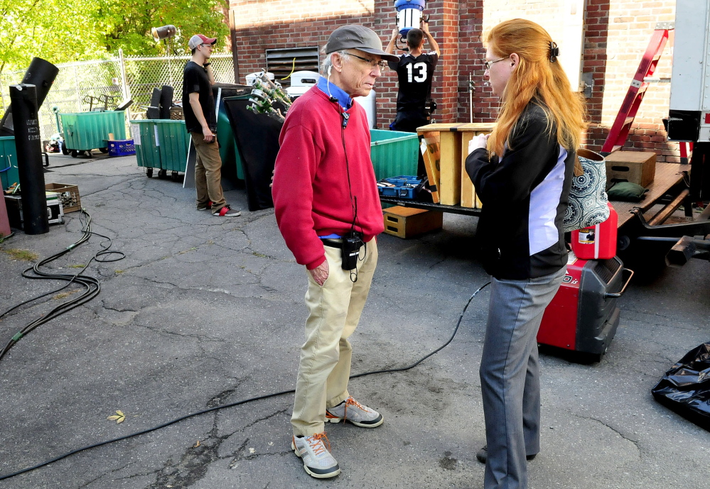 Unit production manager Kip Kippax and Skowhegan Town Manager Christine Almand speak outside the Old Mill Pub in Skowhegan on Wednesday as workers bring equipment into the tavern to film promotional commercials for “American Pickers” and “Down East Dickering.”
