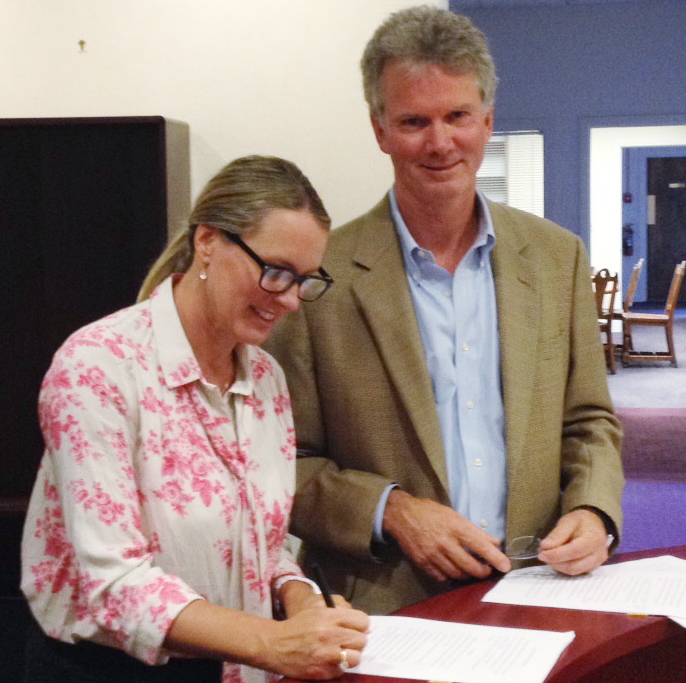 Heather Ashby, who bought 415 Congress St., signs papers Thursday with David Perkins, a lawyer for the building’s former owner.