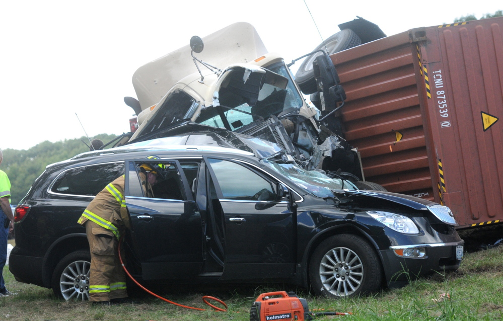 Maine State Police, Kittery fire and police respond to a two-vehicle accident involving an overturned tractor-trailer truck Thursday on the Maine Turnpike in Kittery. Police said a woman died when the truck crashed through a guardrail, crossed a median and hit her SUV head-on.