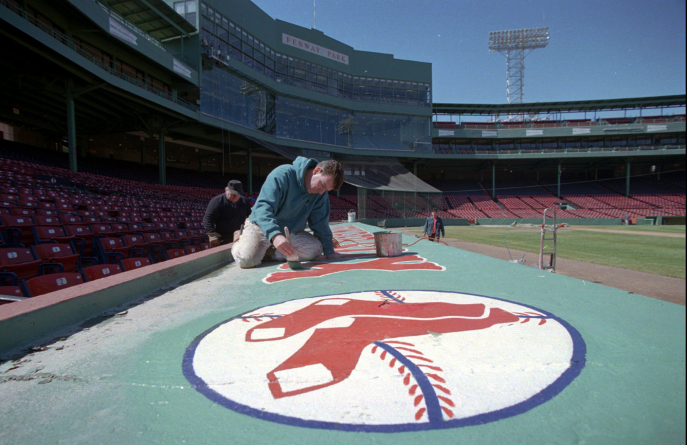 A worker touches up the roof of a dugout at Fenway Park in September. Despite Boston's record snowfall this winter, groundskeepers have no qualms about Opening Day.