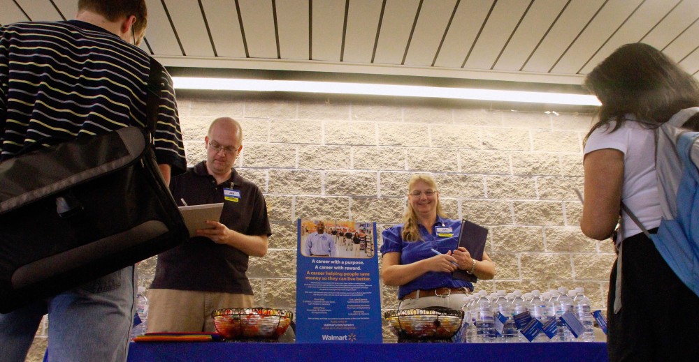 Wal-Mart’s Jon Christians and Lori Harris take job applications and answer questions during a job fair three years ago in Springfield, Ill. Wal-Mart Stores Inc. says it plans to hire 60,000 temporary workers for the crucial holiday season, an increase of nearly 10 percent from last year.