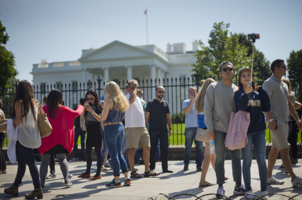 Tourists take photographs in front of the White House in Washington on Saturday.  The Secret Service is coming under renewed scrutiny after a man scaled the White House fence and made it all the way through the front door before being apprehended.