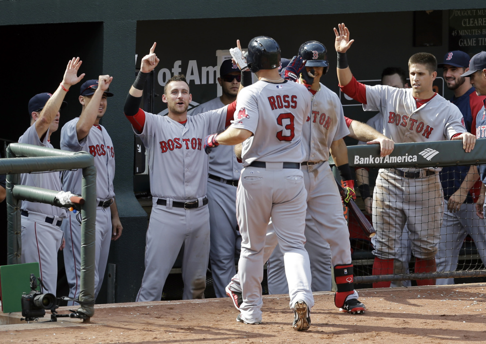 Teammates greet Boston Red Sox’s David Ross (3) after he hit a solo home run in the sixth inning of a baseball game against the Baltimore Orioles, Sunday, in Baltimore.