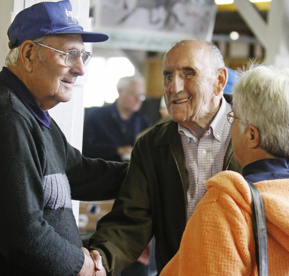 Donnie Richards, center, is greeted Sunday by friends George Chamberlin, left, and Cheryl Johnson of Springvale at a reception in honor of Richards at the Cumberland County Fair.