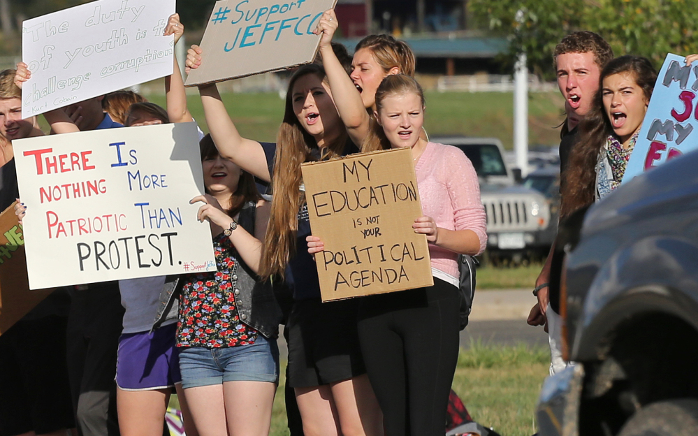 Students hold signs Tuesday at Ralston Valley High School, in Arvada, Colo., as they voice opposition to a conservative-led proposal about the teaching of U.S. history.