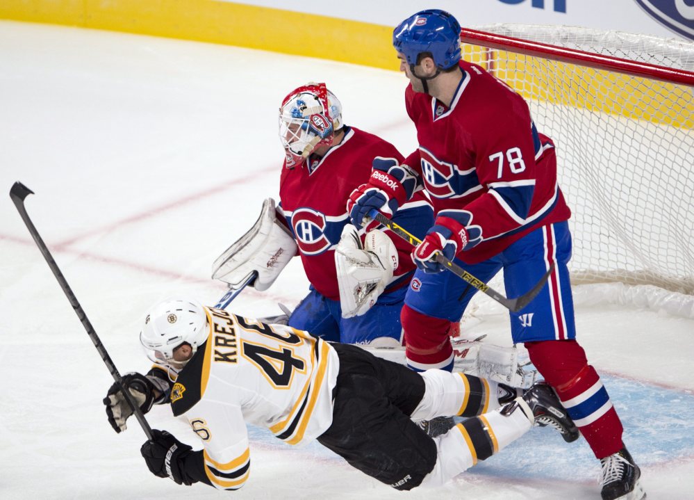 Boston Bruins center David Krejci is knocked to the ice by Montreal defenseman Joe Finley in front of goalie Dustin Tokarski during Tuesday’s exhibition in Montreal.