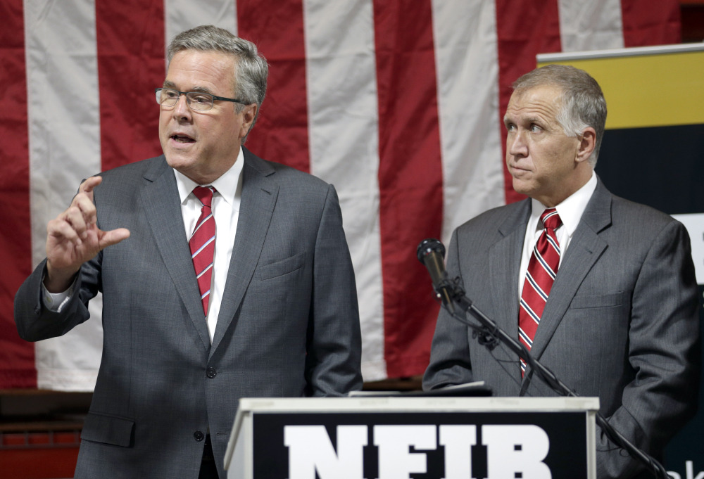 Former Florida Gov. Jeb Bush, left, answers a question as North Carolina Republican Senate candidate Thom Tillis listens Wednesday during an event in support of Tillis in Greensboro, N.C. Such events give Bush a platform to speak about the country’s ills and the prospect of a “new American century.”