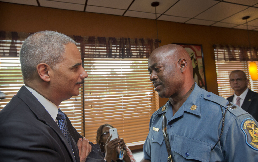 Attorney General Eric Holder speaks with Capt. Ron Johnson of the Missouri State Highway Patrol on Aug. 20 in Ferguson, Mo., where protests raged after a Ferguson police officer shot 18-year-old Michael Brown.