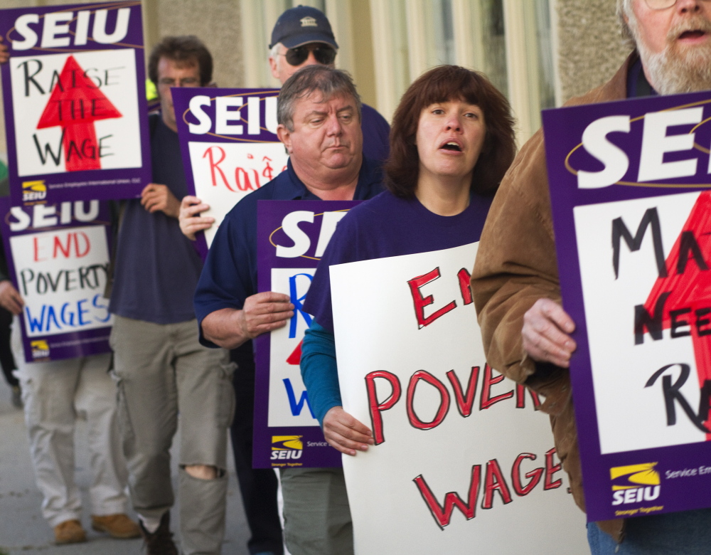 Members of the Maine State Employees Association, SEIU Local 1989, and the Maine AFL-CIO demonstrate outside the Holiday Inn by the Bay in Portland when U.S. House Speaker John Boehner was inside last year. Protesters called for raising the federal minimum wage. Groups in Maine have started an effort to raise the minimum wage statewide.