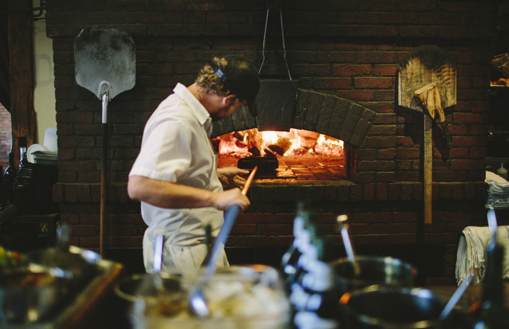 Joshua Doria prepares a wood-burning oven as dinner service starts at Fore Street Restaurant in Portland.