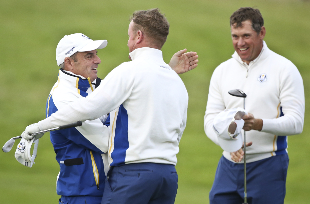 Europe team captain Paul McGinley congratulates Jamie Donaldson and  Lee Westwood, right, on the 17th green after winning  the foursomes match on the second day of the Ryder Cup golf tournament, at Gleneagles, Scotland, on Saturday.