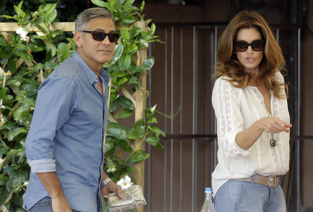George Clooney and Cindy Crawford walk in the garden of the Cipriani hotel in Venice on Saturday. Clooney, 53, and Alamuddin, 36, were married Saturday in Venice.