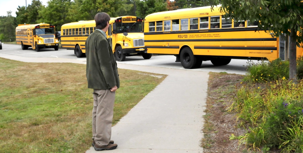 Kent Hoffman, principal of Searsport District High School, watches RSU 20 buses. The future of RSU 20 is uncertain.