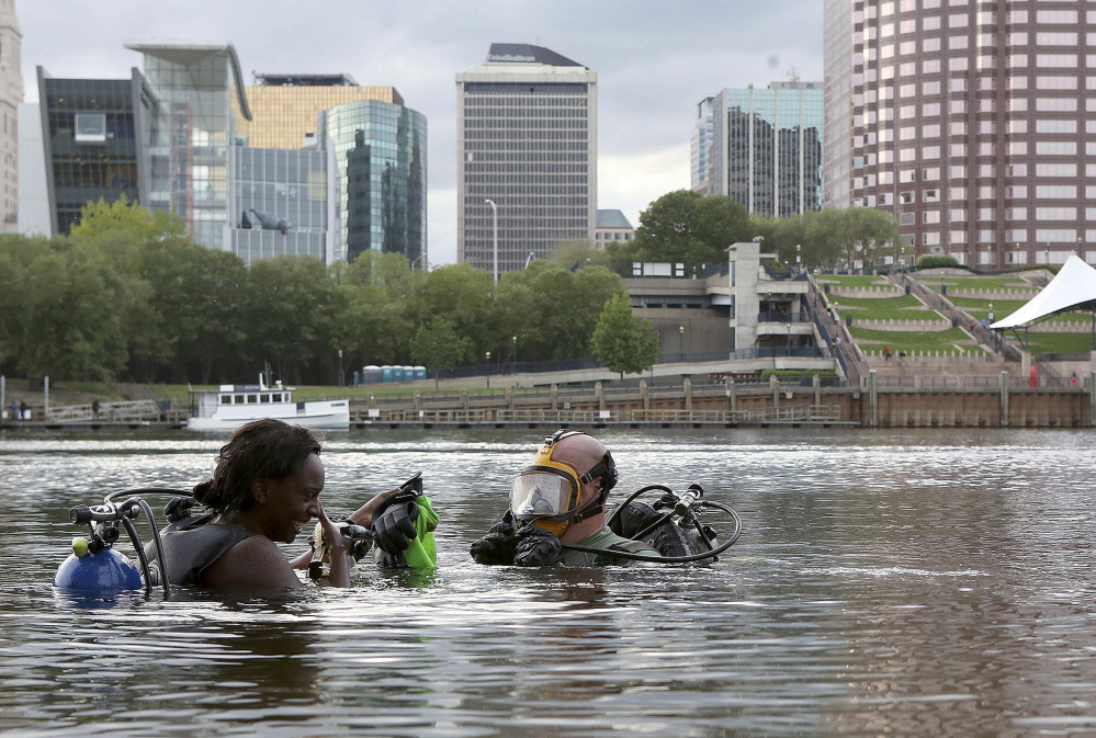 Nicole Green, left, of West Hartford, Conn., and her dive instructor Woodrow Tinsley clear their masks before diving in the Connecticut River, in East Hartford, Conn. Tinsley, an East Hartford police officer, is hoping to identify the ship that sunk in the 1970s.