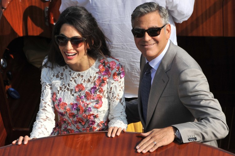George Clooney, wearing his wedding ring, and his wife Amal Alamuddin, cruise the Grand Canal after leaving the Aman luxury Hotel in Venice, Italy, on Sunday.