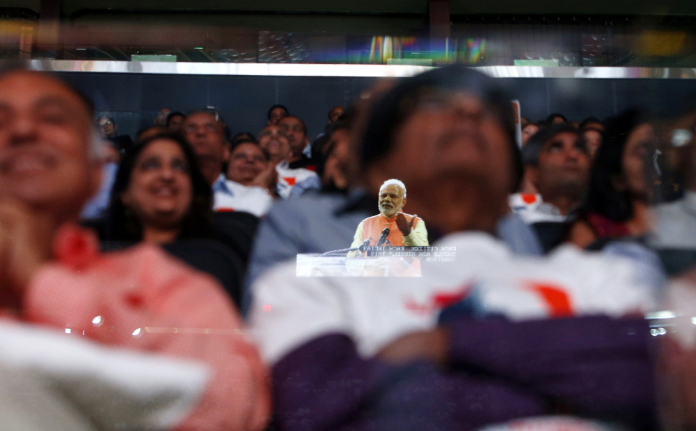 Prime Minister Narendra Modi of India is reflected in a glass barrier as he gives a speech at Madison Square Garden in New York on Sunday. About 30 U.S. lawmakers attended the event, which drew a crowd of 18,000.