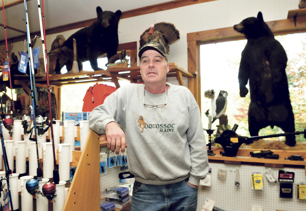 Gerald White stands in his sporting goods store Rivers Edge Sports in Oquossoc surrounded by fishing gear and two stuffed black bears. White said a bear-baiting ban would have a devastating impact on his business and others that depend on the season. “There is no question it would hurt business and we would never recover,” White said.