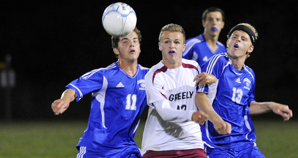 Falmouth, left, Jonah Spiegel, who eventually scored the game’s only goal, and teammate John McConnell, right, battles Greely’s Jacob Nason for the ball during the Yachtsmen’s 1-0 win Monday in Cumberland.