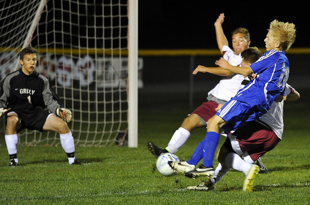 CUMBERLAND, ME - SEPTEMBER 29: Greely #1, goalkeeper John Wright keeps his eye on the ball as Falmouth #18, Mitchell Day, on a breakaway attack, gets tackled by two Greely defenders as Greely hosts Falmouth in Boys High School Soccer action. (Photo by Gordon Chibroski/Staff Photographer)
