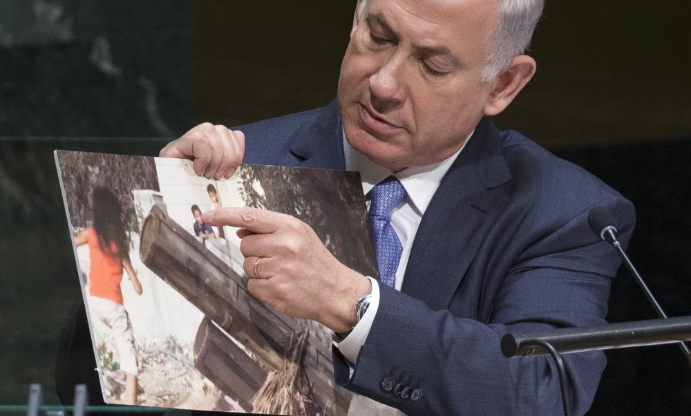 Israel’s Prime Minister Benjamin Netanyahu points to a photo he says shows rocket launchers placed in residential neighborhoods of Gaza, as he addresses the 69th session of the United Nations General Assembly at U.N. headquarters Monday.