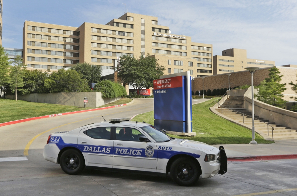 A police car passes the entrance to Texas Health Presbyterian Hospital in Dallas, where a patient has tested positive for Ebola, federal health officials said Tuesday.