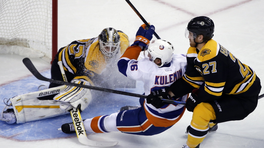 Nikolai Kulemin of the Islanders gets checked from behind by Bruins defenseman Dougie Hamilton in front of goalie Niklas Svedberg in the first period of Tuesday night’s preseason game in Boston. The Islanders won 5-3 with two goals in the final 3:19 of the third period.