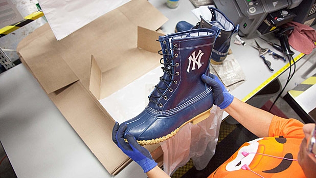 A worker at L.L.Bean holds up a pair of boots made specially for Derek Jeter of the Yankees, who will play his final game of his career on Sunday at Fenway Park.
