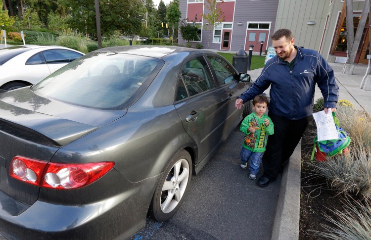 Jason Prosser, with his son Zachary, 3, in Seattle, Wash., is postponing another child because child care is so expensive. The Associated Press