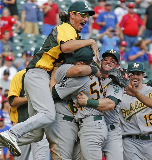 Oakland A's pitcher Jeff Samardzija, left, and other teammates embrace starting pitcher Sonny Gray after the final out in their wild card-clinching 4-0 win against the Texas Rangers in Arlington on Sunday. The Associated Press